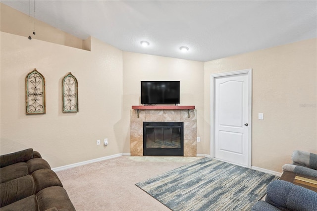 living room featuring a tile fireplace and carpet flooring