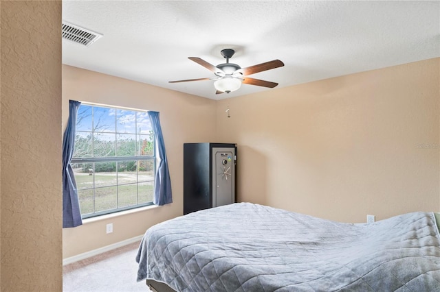 bedroom featuring ceiling fan, light colored carpet, and multiple windows