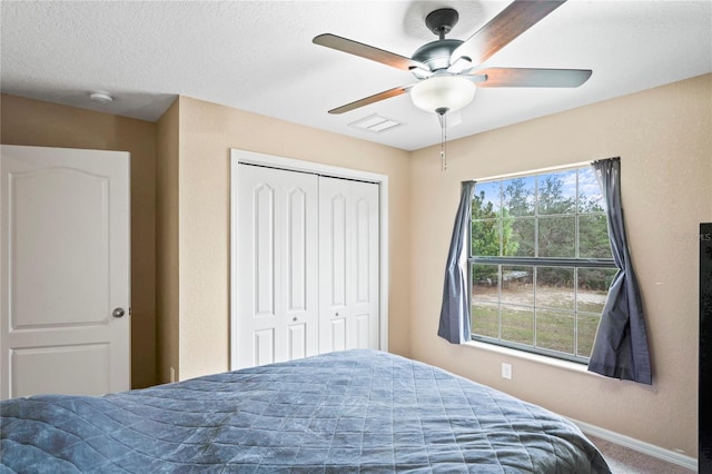 bedroom featuring ceiling fan, multiple windows, a closet, and carpet floors