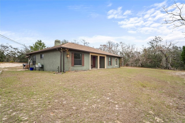 rear view of property featuring a lawn