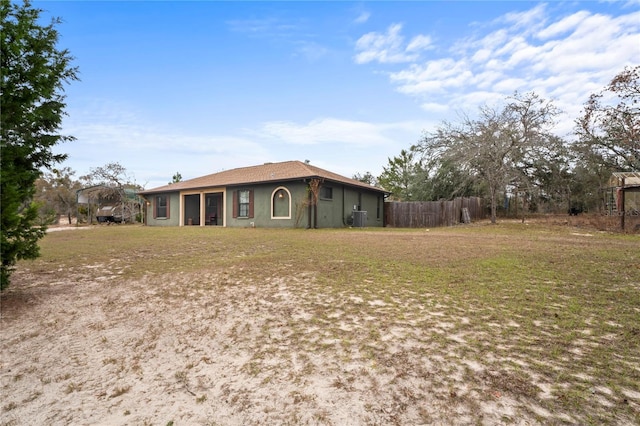 exterior space featuring cooling unit and a front yard