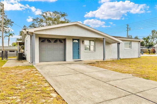 ranch-style house featuring a front yard, a garage, and central AC unit