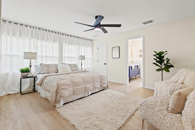 bedroom with connected bathroom, ceiling fan, and light wood-type flooring