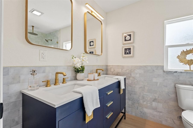 bathroom featuring a shower, toilet, vanity, tile walls, and hardwood / wood-style flooring