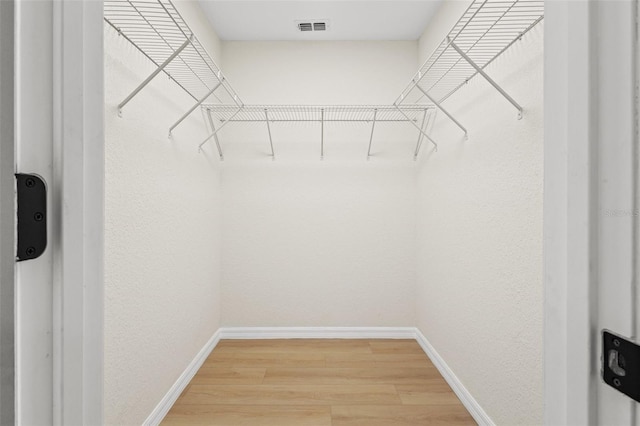 walk in closet with hardwood / wood-style floors