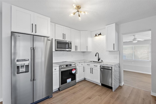 kitchen featuring sink, white cabinetry, stainless steel appliances, and light wood-type flooring