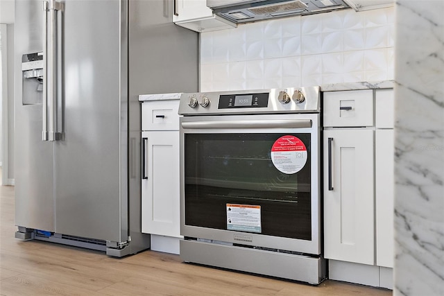 kitchen featuring white cabinets, backsplash, stainless steel appliances, and light hardwood / wood-style floors