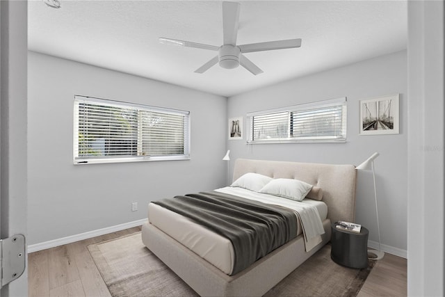 bedroom featuring multiple windows, ceiling fan, and wood-type flooring