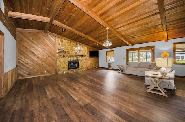 unfurnished living room featuring vaulted ceiling with beams, dark wood-type flooring, wooden ceiling, and a stone fireplace