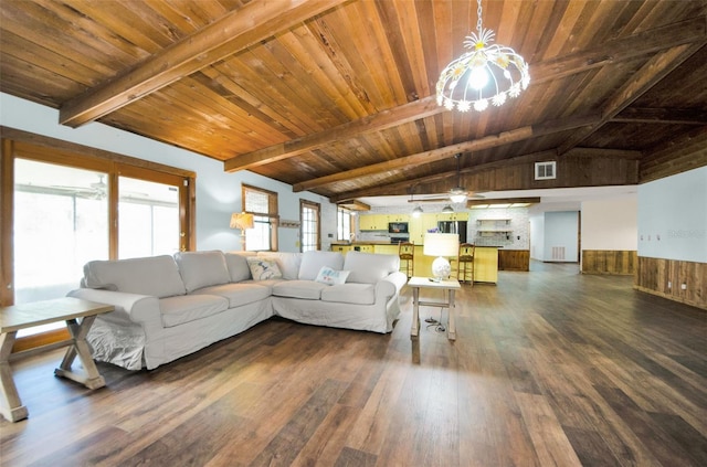 unfurnished living room with a wealth of natural light, lofted ceiling with beams, dark wood-type flooring, and wood ceiling