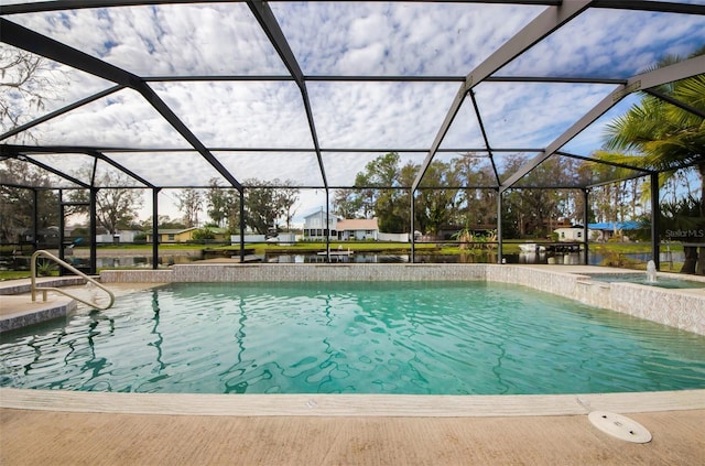 view of pool featuring glass enclosure, pool water feature, and a water view