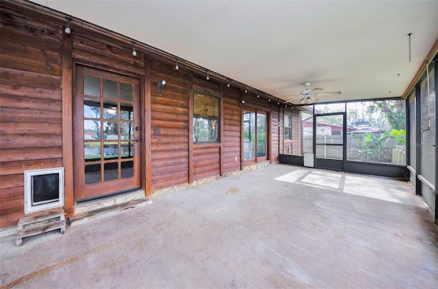 unfurnished sunroom with ceiling fan