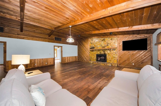 living room with wood walls, a wood stove, wooden ceiling, hardwood / wood-style flooring, and beamed ceiling