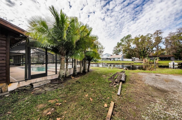 view of yard featuring glass enclosure and a water view