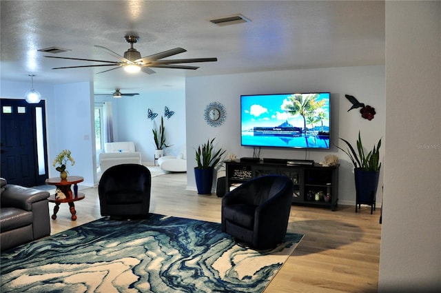 living room featuring wood-type flooring and a textured ceiling