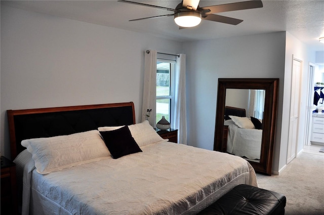 bedroom featuring ceiling fan, light colored carpet, and a textured ceiling