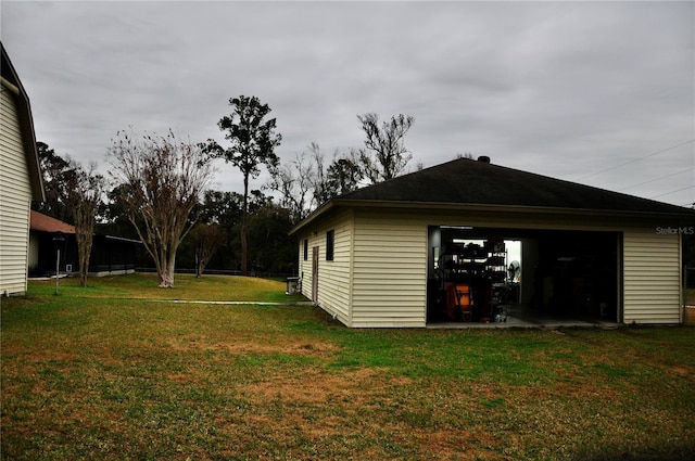 view of property exterior featuring a lawn, a garage, and an outdoor structure