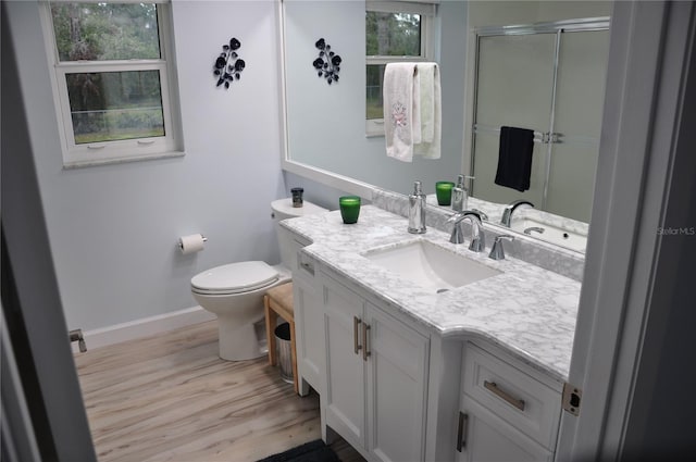 bathroom featuring hardwood / wood-style flooring, vanity, toilet, and walk in shower