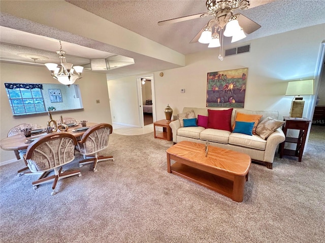 living room with carpet flooring, a textured ceiling, and ceiling fan with notable chandelier