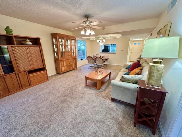 living room with carpet, ceiling fan, and a textured ceiling