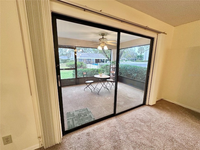 entryway featuring carpet flooring, ceiling fan, and a textured ceiling