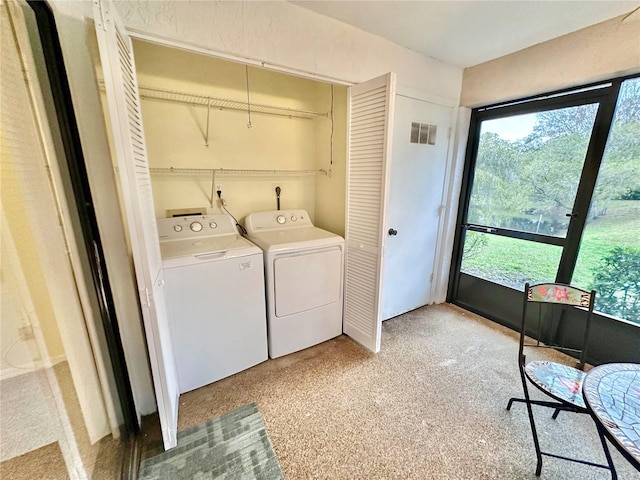 laundry area featuring separate washer and dryer and light carpet