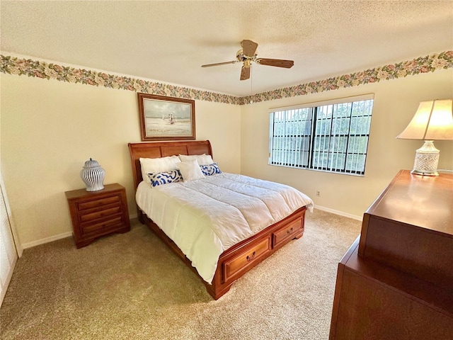 carpeted bedroom featuring ceiling fan and a textured ceiling