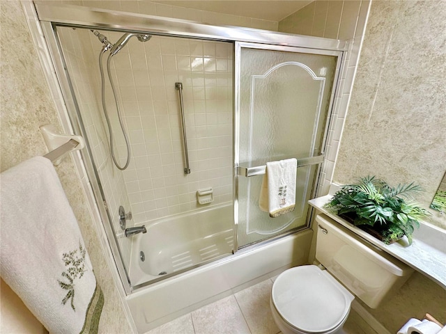 bathroom featuring toilet, tile patterned floors, and enclosed tub / shower combo