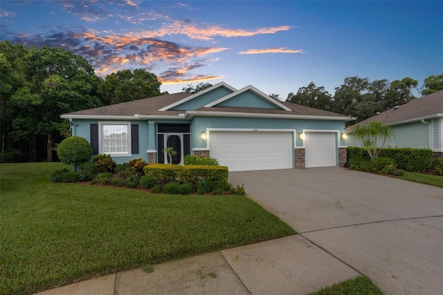 view of front of house with a garage and a lawn