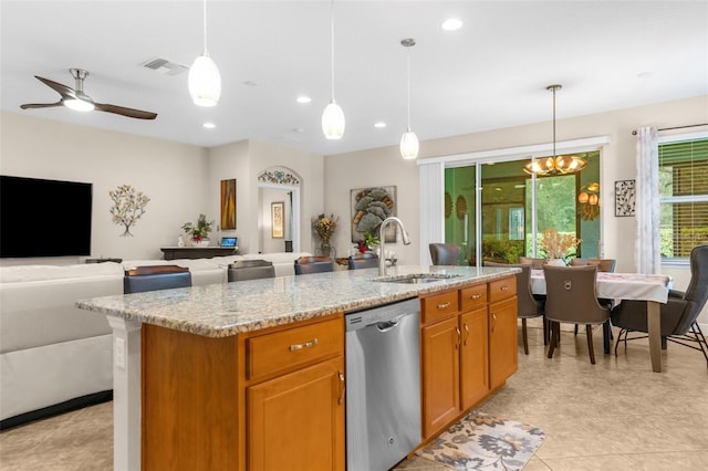 kitchen featuring stainless steel dishwasher, pendant lighting, and a center island with sink