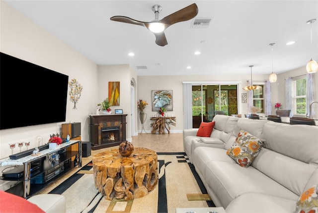 living room with ceiling fan and a wealth of natural light