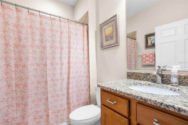 bathroom with curtained shower, vanity, and toilet