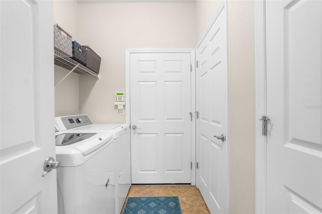 clothes washing area featuring washer and clothes dryer and light tile patterned flooring