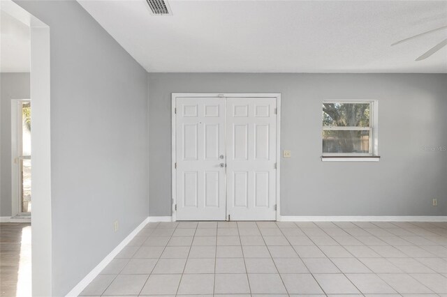 foyer entrance featuring ceiling fan and light tile patterned flooring