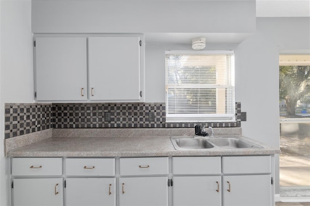 kitchen featuring white cabinetry, sink, and tasteful backsplash