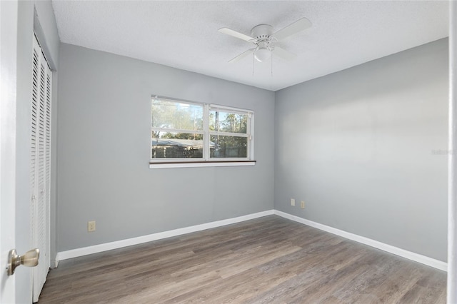 unfurnished bedroom with a textured ceiling, dark hardwood / wood-style flooring, and ceiling fan