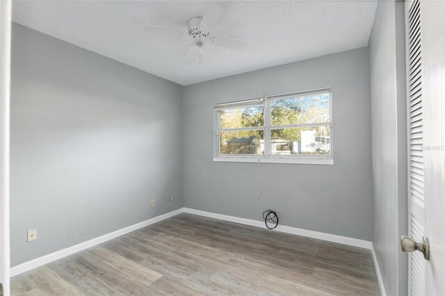 empty room featuring light wood-type flooring, a textured ceiling, and ceiling fan