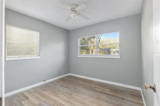 spare room featuring a textured ceiling, light hardwood / wood-style flooring, and ceiling fan