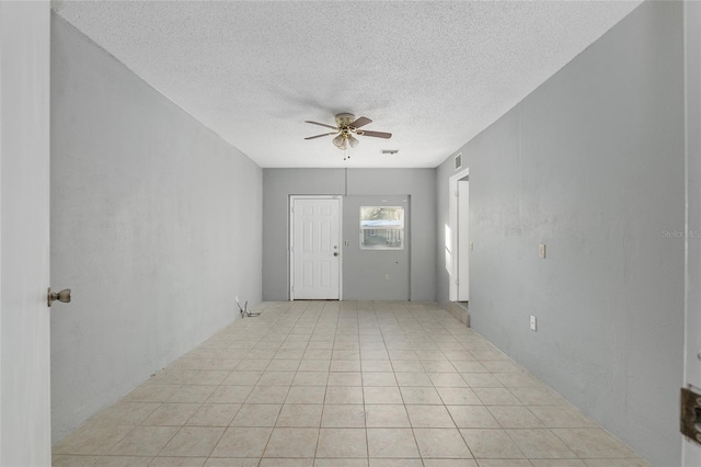 empty room featuring ceiling fan and a textured ceiling