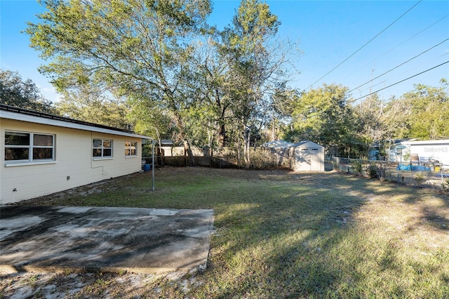 view of yard with a storage shed and a patio