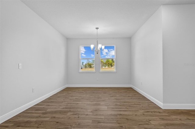 unfurnished dining area with a chandelier and dark hardwood / wood-style floors