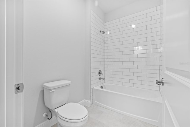 bathroom featuring tile patterned flooring, tiled shower / bath, and toilet