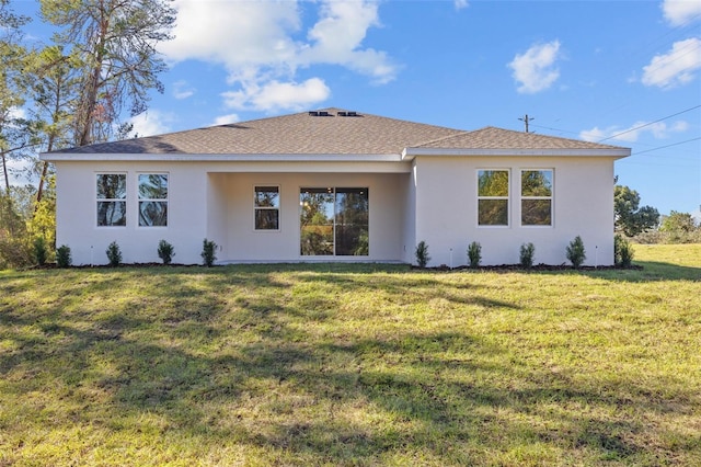 rear view of property featuring a lawn