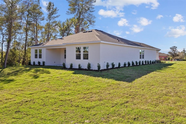 back of property with a lawn