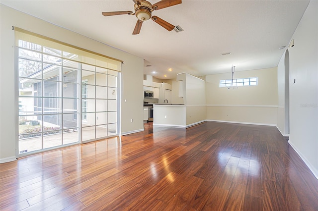 unfurnished living room with ceiling fan and dark hardwood / wood-style flooring