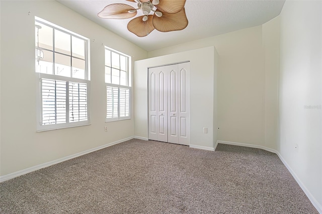 unfurnished bedroom with ceiling fan, carpet, and a closet