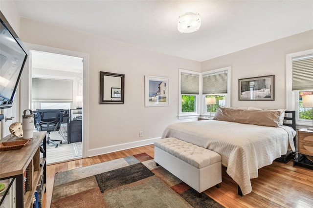 bedroom featuring wood finished floors and baseboards