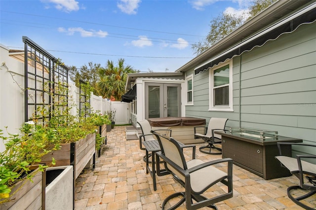 view of patio with a fenced backyard, a vegetable garden, and a hot tub