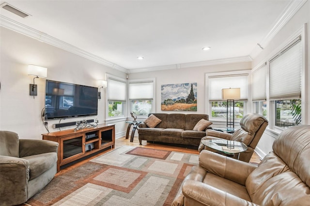 living area with plenty of natural light, visible vents, and crown molding