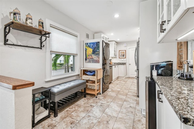 kitchen featuring visible vents, glass insert cabinets, white cabinets, and dark stone counters